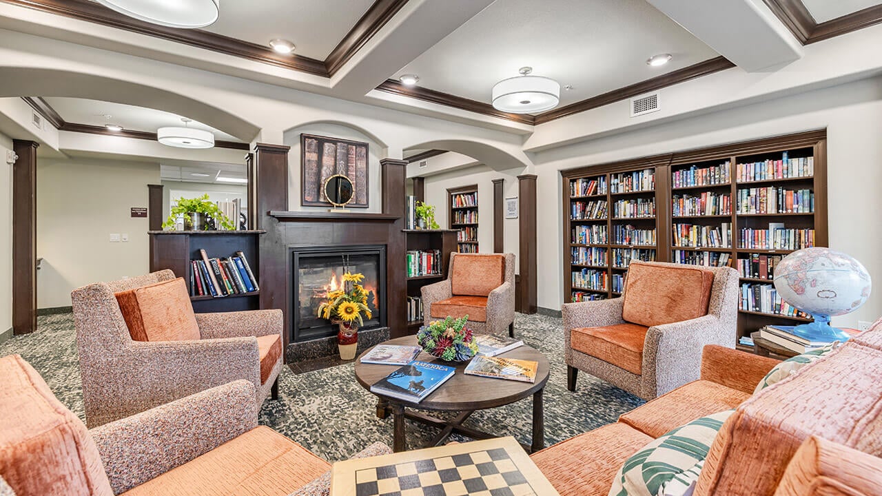 The library at Williams Place with shelves of books and comfortable seating